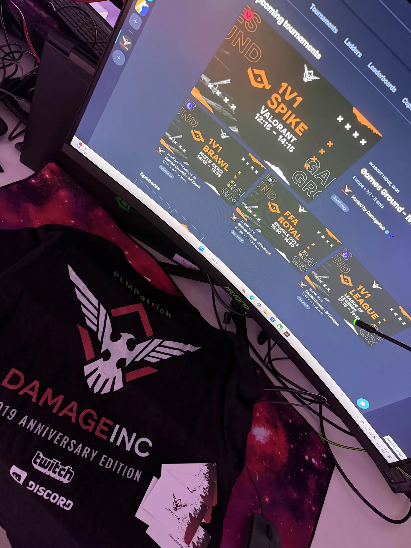 A tournament overview on a station screen next to a Damage Inc mousepad